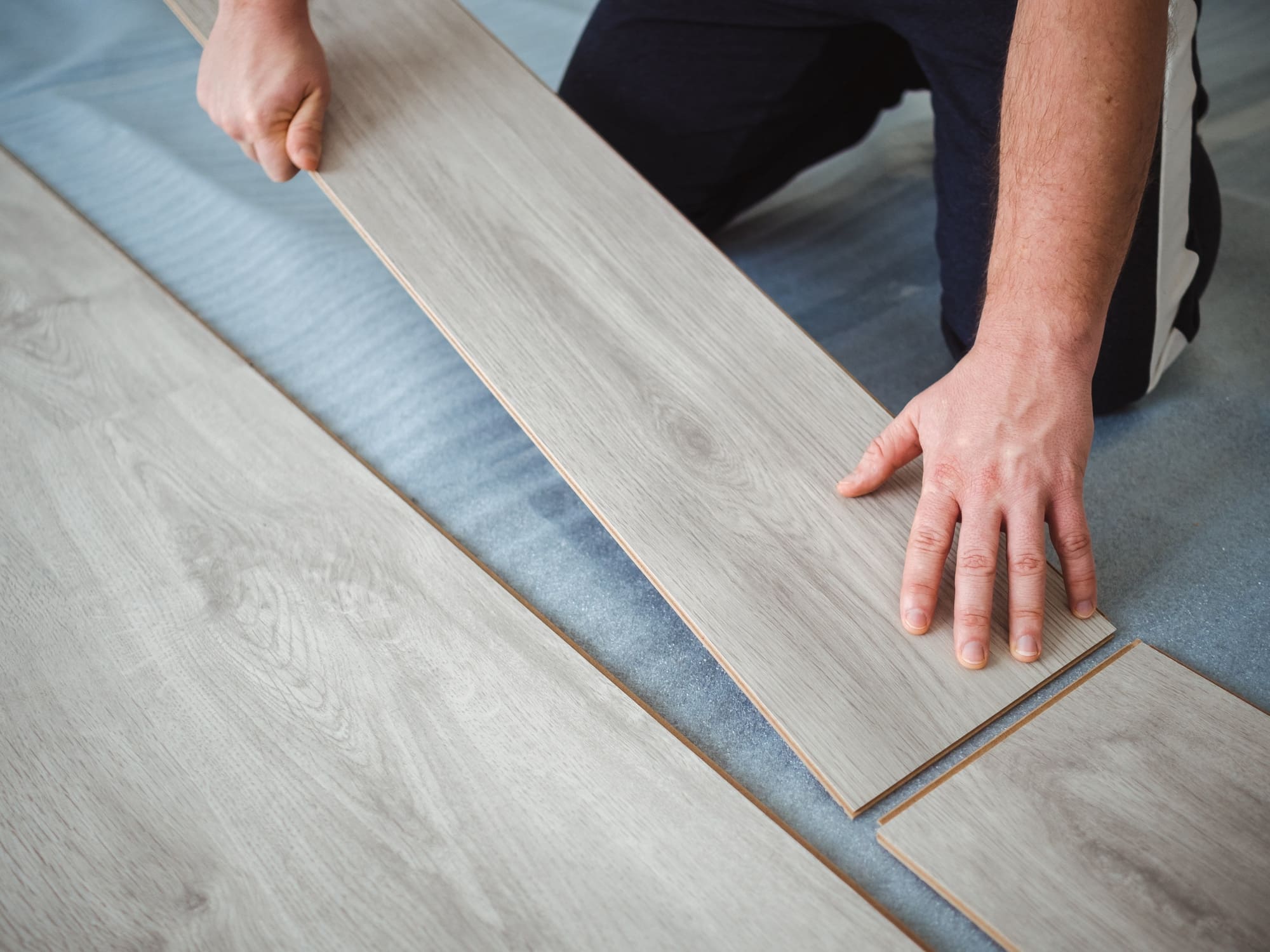 A man holds a laminate board in his hands